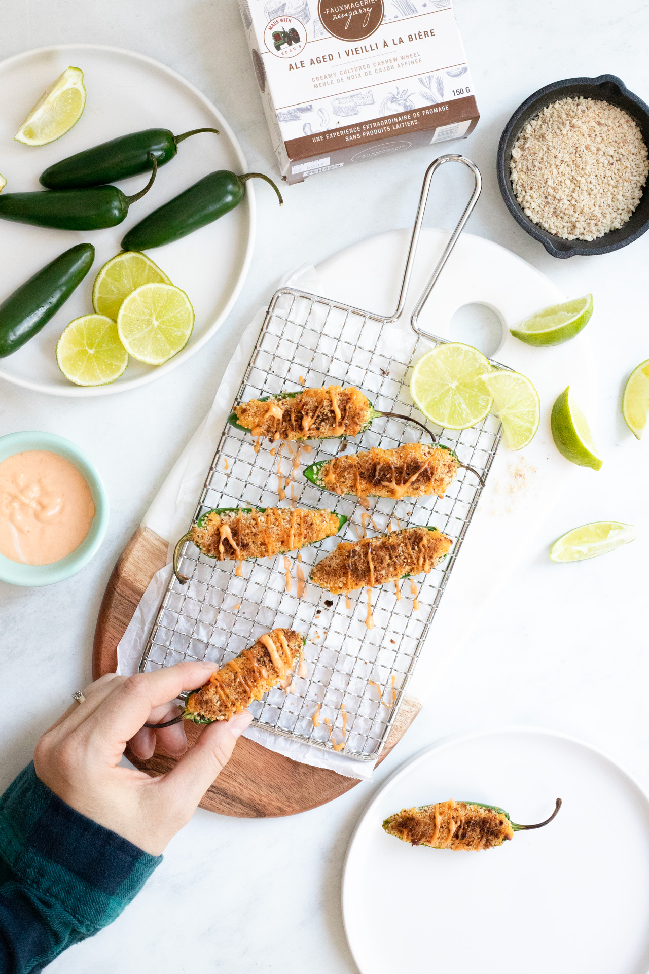 Vegan Jalapeno Poppers with a hand and plate