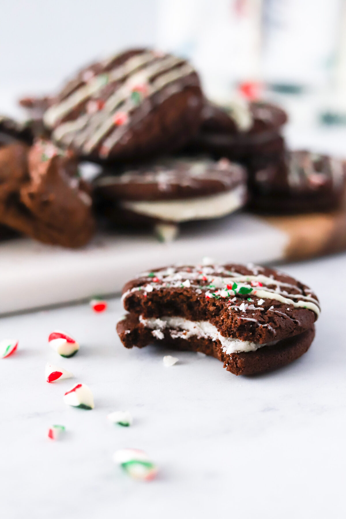 bite shot of Vegan Chocolate Peppermint Sandwich Cookies with candy cane