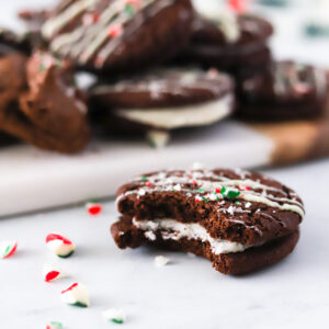 bite shot of Vegan Chocolate Peppermint Sandwich Cookies with candy cane