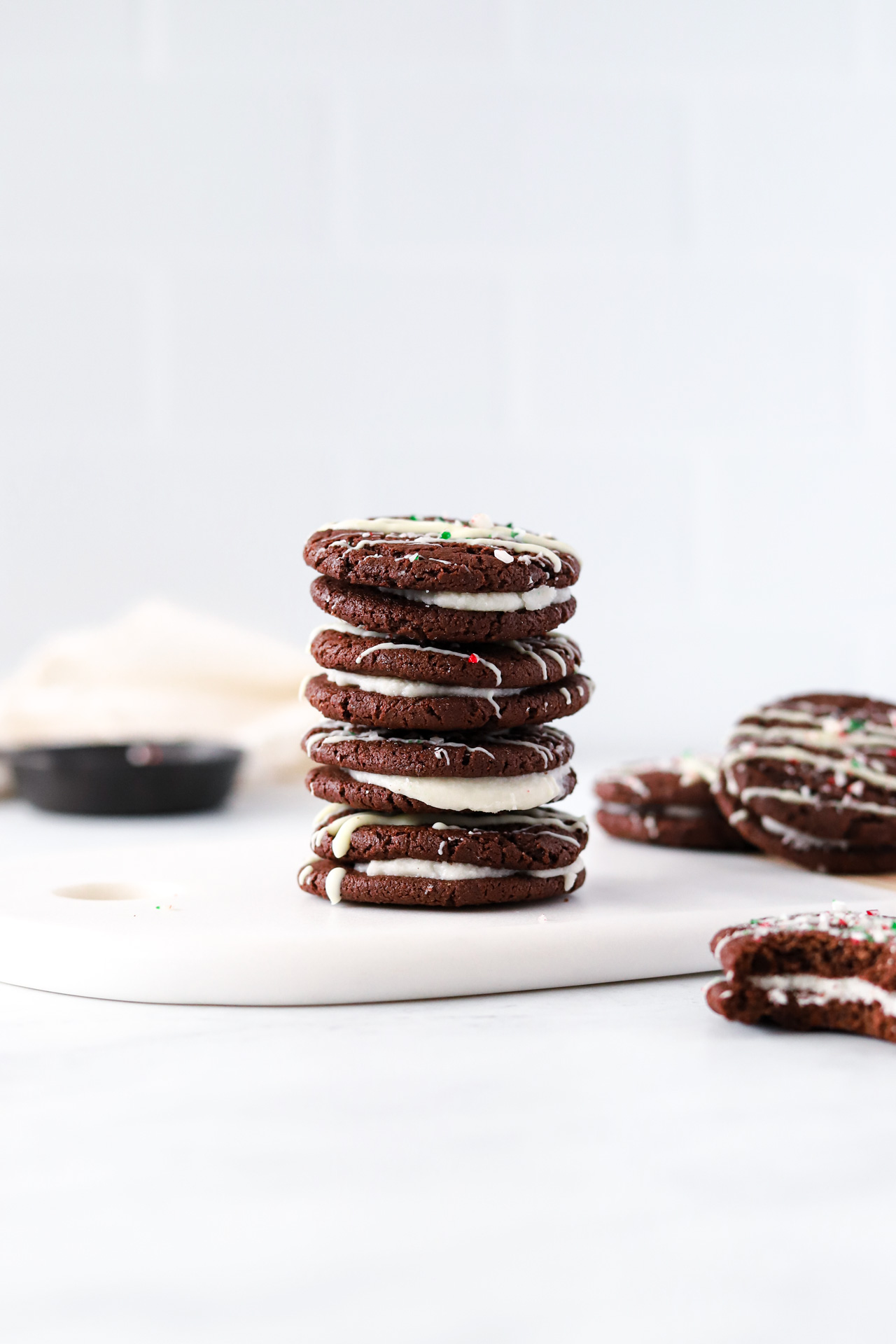 Stack of Vegan Chocolate Peppermint Sandwich Cookies with bite from cookie