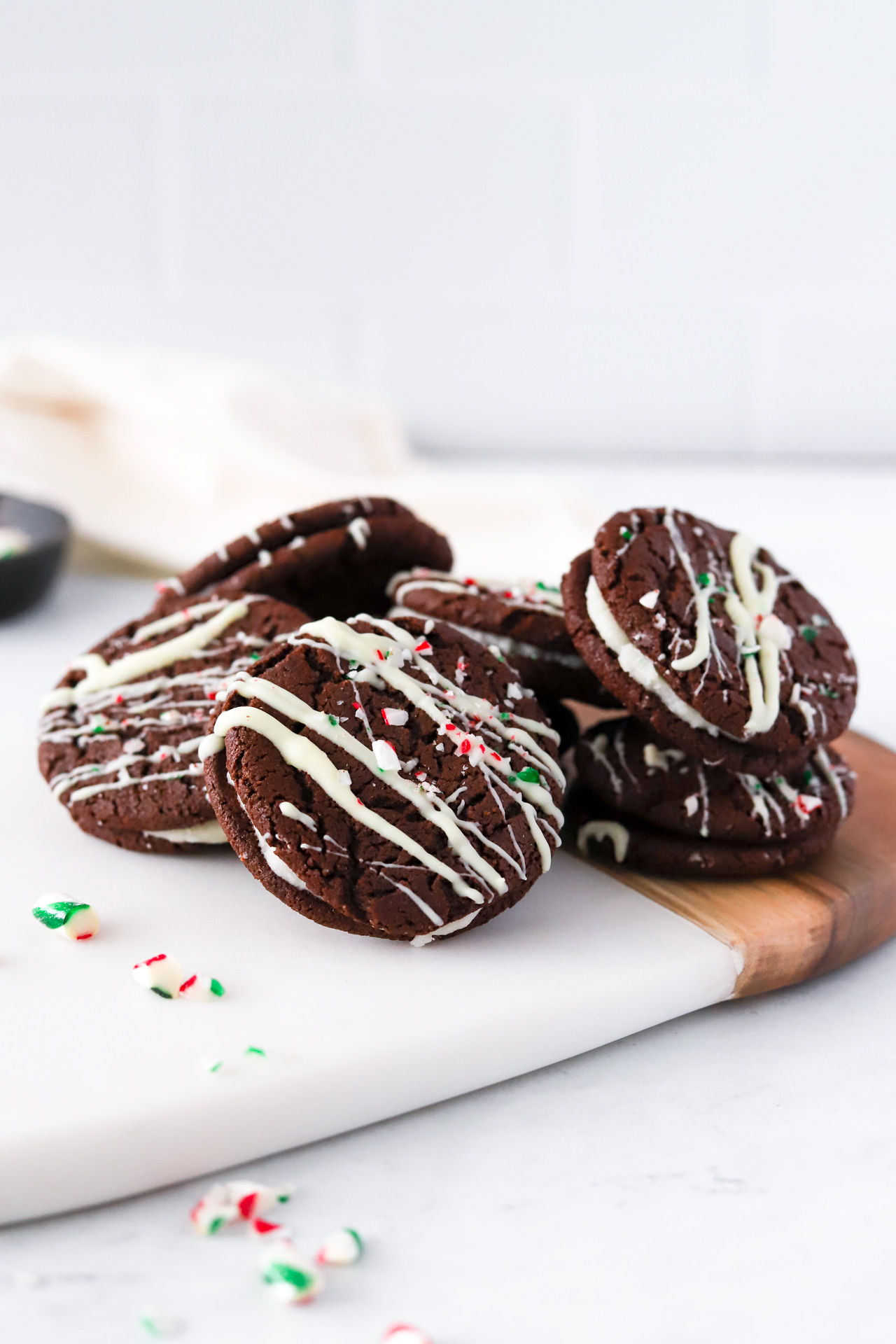 serving board of Vegan Chocolate Peppermint Sandwich Cookies with candy cane