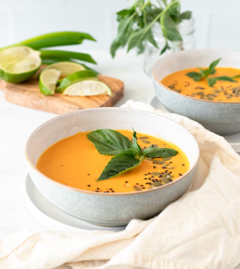 Roasted Butternut Squash Coconut Curry Soup on a table for two